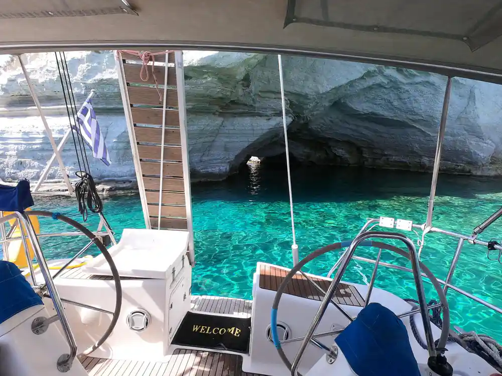 The boat's cockpit and wheel above clear turquoise water