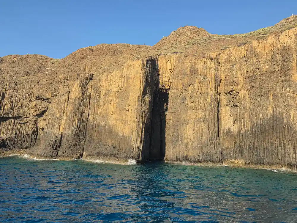 Columnar basalt cliff rising straight from the sea