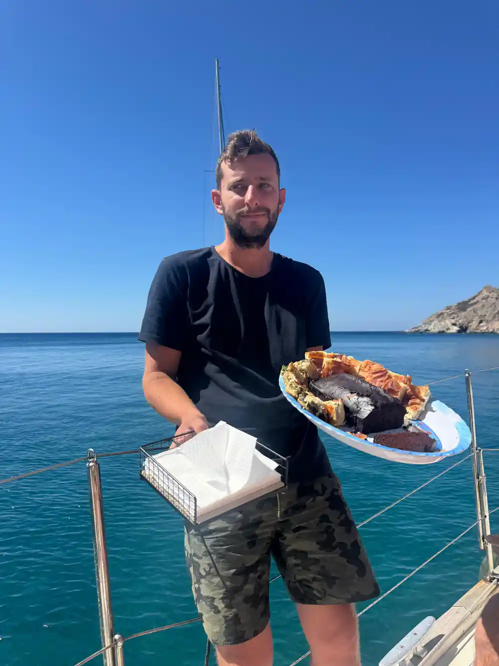 Crew member holding a cake out on the boat's rail