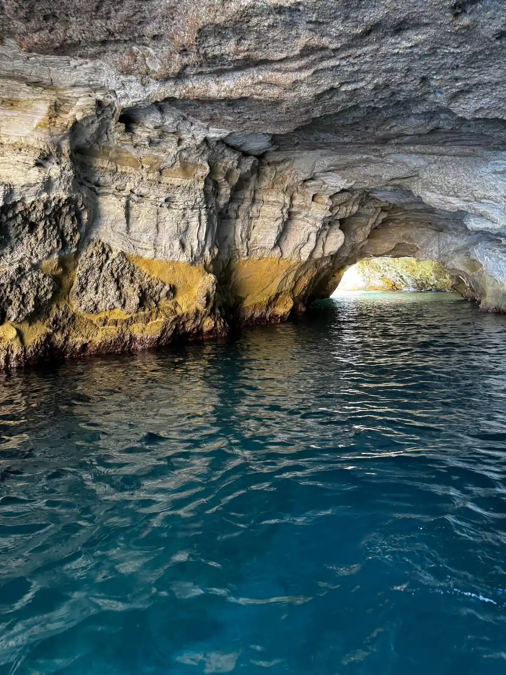 Inside a sea cave with an opening to bright water beyond