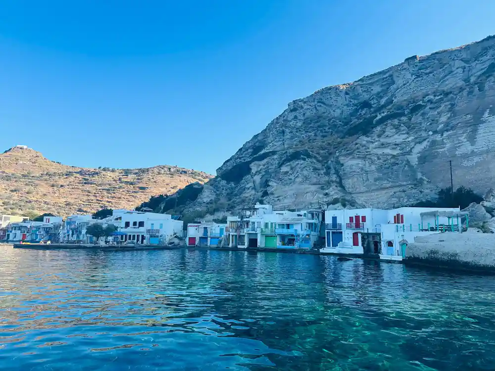 Painted boathouse doors below a whitewashed village