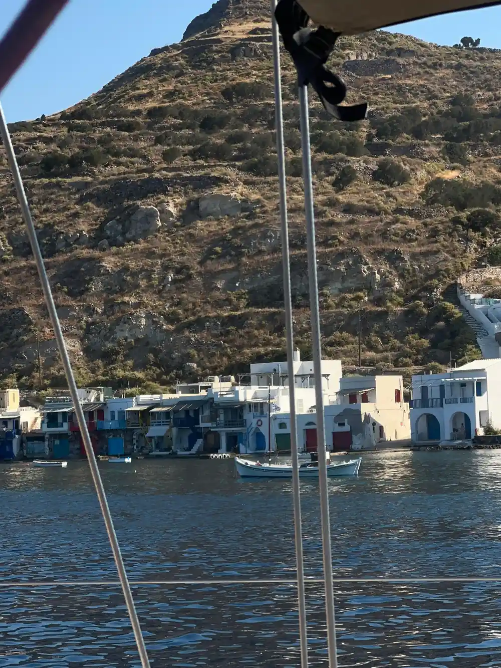 Painted boathouses seen through the boat's rigging