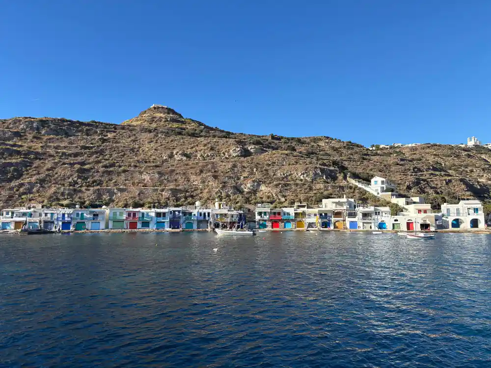 Row of painted boathouse doors along the waterline