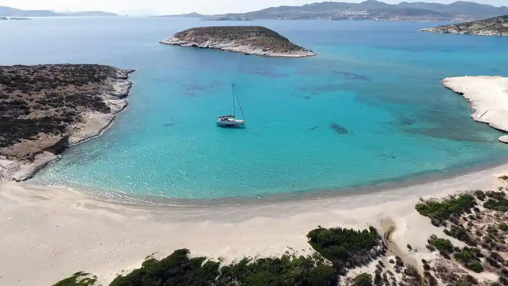 Sailing boat anchored off a low uninhabited island