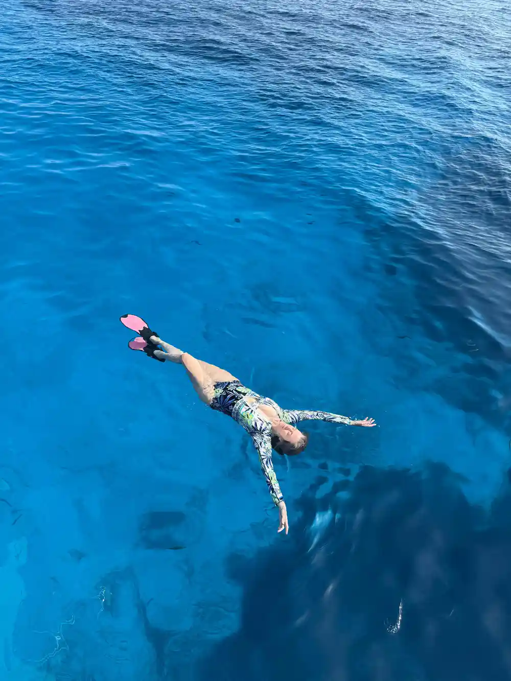 Snorkeller floating face down in deep blue water
