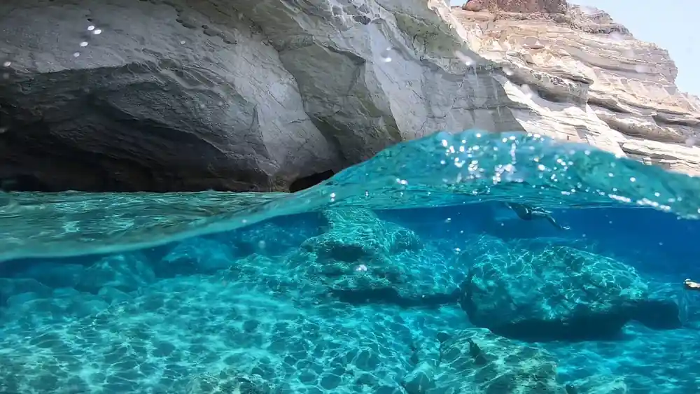 Split view of clear water against a white rock face