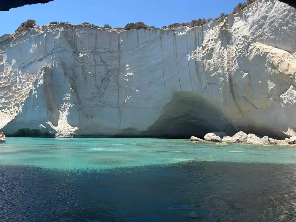 White rock arch and cave above shallow clear water