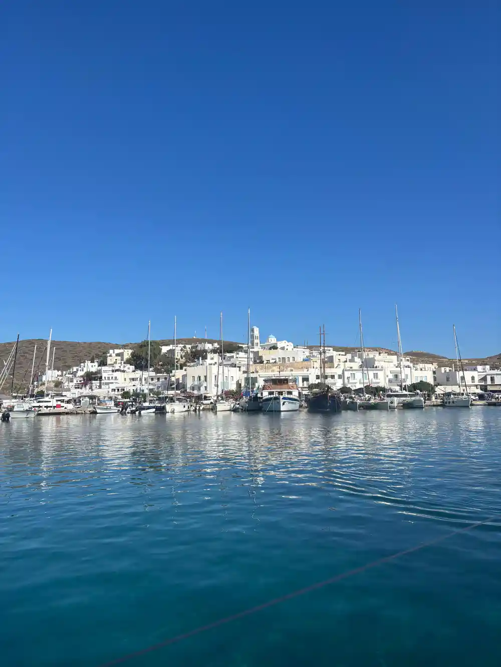 Whitewashed harbour village with yachts along the quay